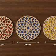 hree round wooden coasters with red, blue, and yellow color designs placed on wooden table
