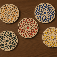 Set of five wooden tea coasters in assorted colors arranged on a wooden table